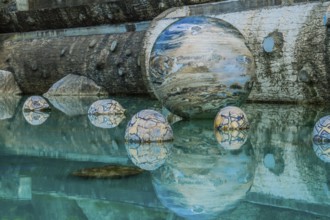 Sejong, South Korea, August 8, 2019: Marble sphere surrounded by smaller spheres in pool of water