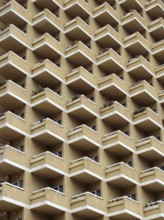 Large highrise modern apartment building with large number of repeating geometric balconies in