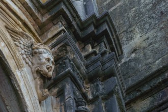 Ronda, malaga, spain gargoyle on the facade of a stone church darkened by time