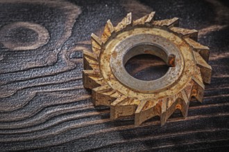 Rusted rotary cutter on vintage wood background construction concept