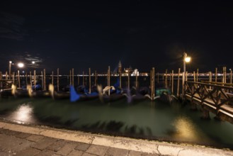Venetian gondolas, boat dock at St Mark's Square, church of San Giorgio Maggiore in the background,