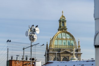 View of a historic dome with antennae and birds in a cityscape in winter, Czech National Museum