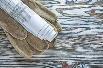 Leather safety gloves construction plans on vintage wooden board