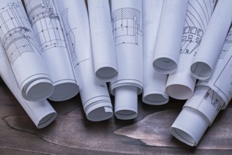 Rolls of construction plans on pine wooden vintage board maintenance concept