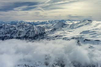 Aerial view of snow mountain range landscape with clouds. Alps mountains, Austria, Europe