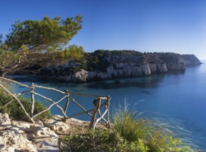 A landscape view of the idyllic Cala Macarella in southern Menorca with a hiking trail in the