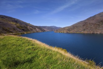 The surroundings of the city of Cromwell among mountains and lakes. Blue sky and light clouds. New