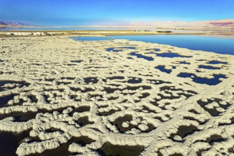 The blue water is surrounded by pink mountains. The picturesque Dead Sea is covered with patterns