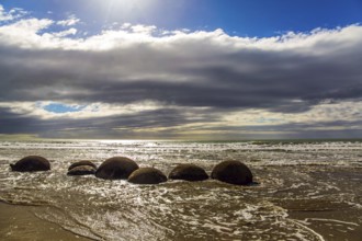 Moeraki boulders. Ocean tide begins. Group of large round boulders on the coast of the South Island