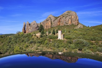 The rocks are beautifully reflected in the shiny surface of the car. Aguero village at the foot of