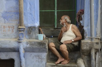 Old man shaving in front of house, jodhpur, rajasthan, India, Asia