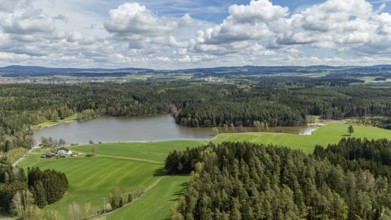 Green landscape with a lake, surrounded by forests and fields under a cloudy sky, Tirschenreuth,