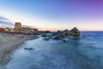 Old historic tower from the 16th century and rocks at sunset on the beach, long exposure, Torre di