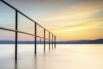 Railing in the lake in the warm light of the sunset, quiet atmosphere, lido, Litzelstetten, Lake