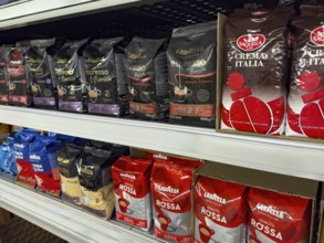 Display shelf with various types of packs of unground coffee beans, Germany, Europe