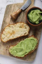 Ciabatta with avocado pasta, breakfast, on a chopping board, top view, homemade, no people