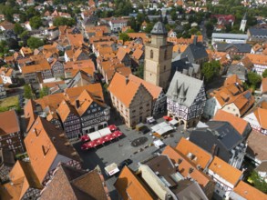 Bird's eye view of the lively market square of a historic town with half-timbered houses and a