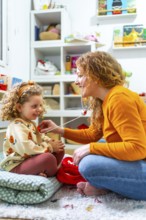 Vertical photo of a caucasian mother listening the beat of daughter heart with fake stethoscope