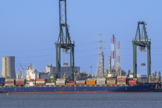 Gantry cranes and stacked containers on container ship docked at container terminal in the port of