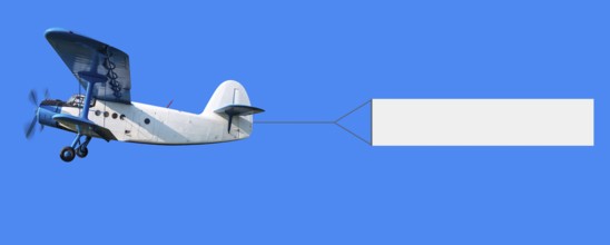 biplane with a banner in the sky