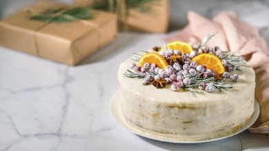 Winter homemade cake on white marble background. White cream christmas cake decored rosemary,