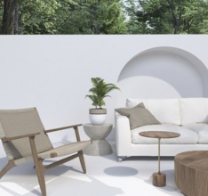 Patio setup with a white sofa, armchair, and plants in a serene environment
