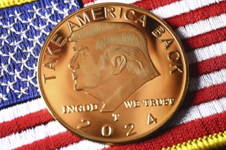 Election campaign coin with portrait of Donald Trump on USA flag, symbolic photo US presidential