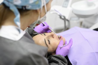 Dentist hygienist making oral hygienic cleaning in dentistry for young woman. Using professional