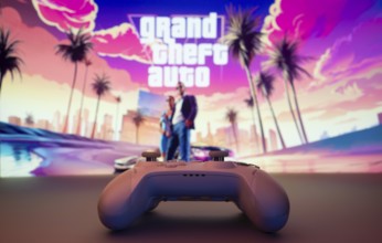 A close-up of a white gamepad with the Grand Theft Auto VI seen on screen in the background. GTA VI