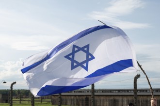 The flag of Israel in the background barbed wire fence of a concentration camp