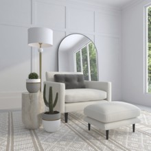 Bright living room with an armchair, plants, lamp, and large mirror