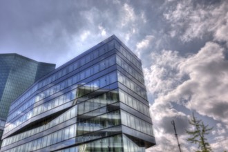 Modern building with glass facade in front of a cloudy sky and reflecting light, Prime Tower