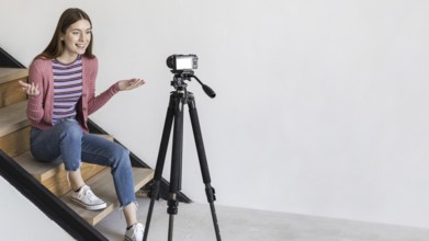 Blogger recording with camera sitting stairs. Resolution and high quality beautiful photo