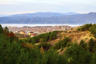 Aerial autumn morning view of Sandanski, Bulgaria with colorful forest trees and fog