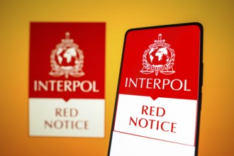 In this photo illustration, the Interpol Red Notice logo is displayed on a smartphone screen