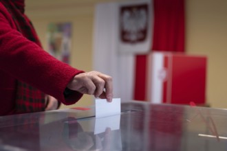 Voter's hand putting the vote into the ballot box.