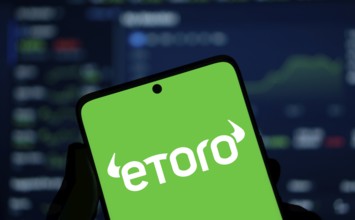 etoro logo is displayed on smartphone. eToro is a social trading and multi-asset investment company