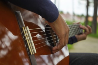 Playing Guitar in Green Park. Guitar Body. Close-Up Shot