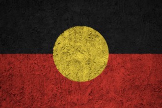 Australian Aboriginal flag painted on the cracked grunge concrete wall