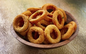 Deep fried onion rings, appetizer, with tomato sauce, on a wooden plate, without people, favorite