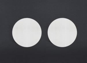 Two white circular papers symmetrically placed on a dark background, Blank white Business card