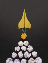 Launching paper rocket with jet stream of paper balls, creativity concept or new ideas metaphor,