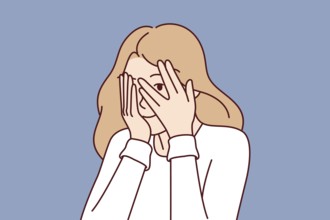 Woman covers eyes with hands and peeps, refusing to see unpleasant things and hiding from problems.