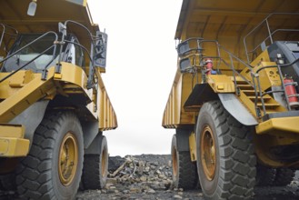 Two 130 ton tiptrucks waiting for work at an open cast coal mine, Westland, New Zealand, Oceania
