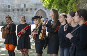 Group female university students musicians perform in street, city of Guimaraes, northern Portugal