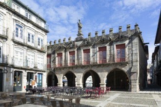 Tables and chairs, historic buildings in Largo da Oliveira square, city of Guimaraes, northern
