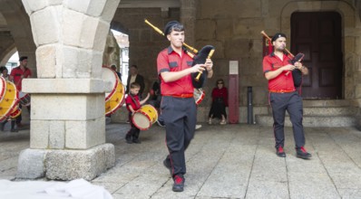 Traditional drum and pipe band perform on city streets on May Day 2025, Guimaraes, Braga district,
