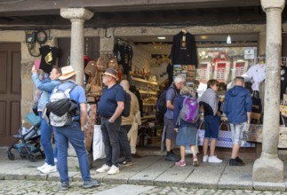 People in street outside tourist souvenir shop, city of Guimaraes, northern Portugal