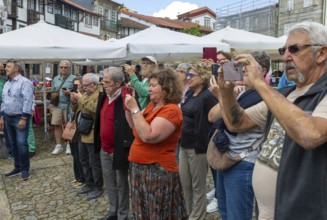 People taking photos with their phones, Praça de São Tiago, city of Guimaraes, northern Portugal