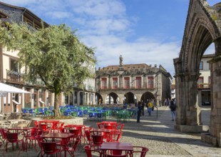 Tables and chairs, historic buildings in Largo da Oliveira square, city of Guimaraes, northern